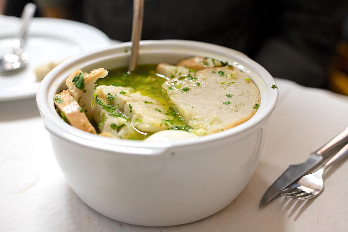 Açorda de marisco traditional soup of Portugal in a white bowl.