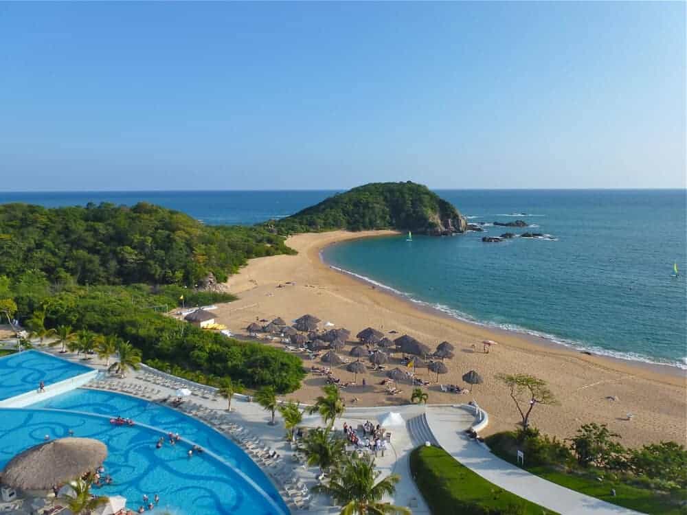 View of the swimming pool and beach at Secrets Resort in Huatulco in Oaxaca, Mexico. 