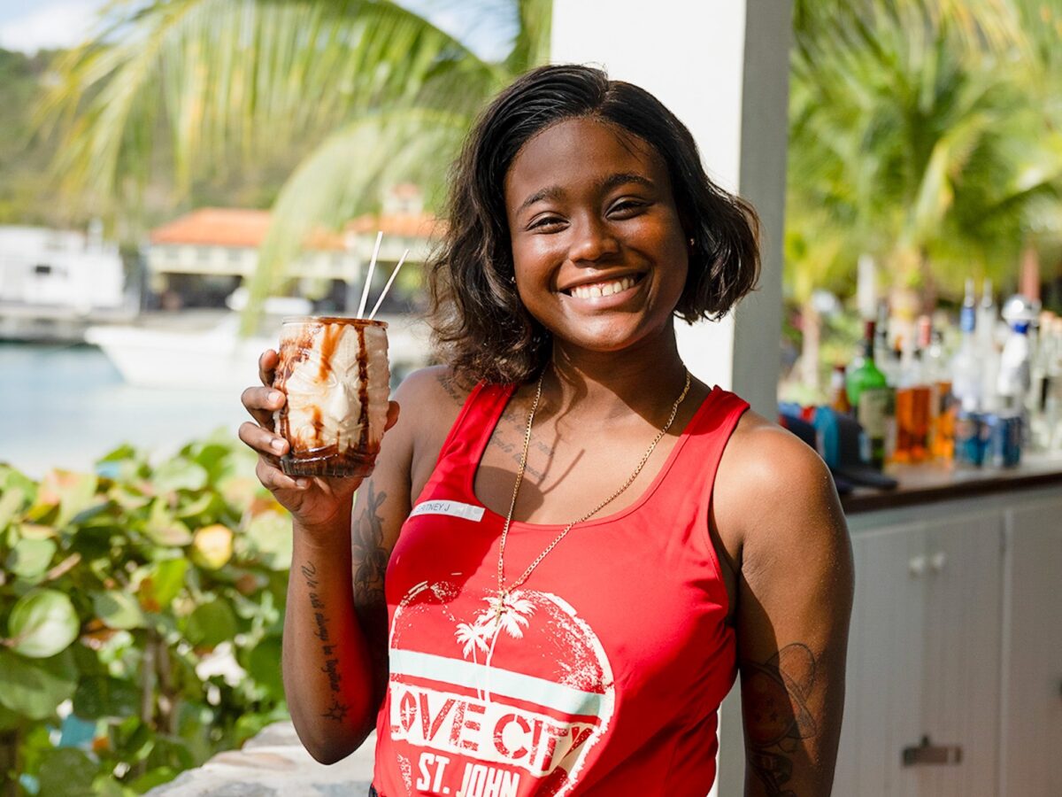 Young woman holding a Bushwacker cocktail.