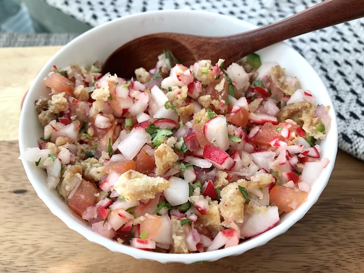 A white bowl of Guatemalan chojin, pork rind and radish salad.