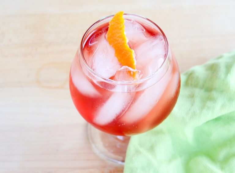 Venetian Blush Campari orange cocktail with a green napkin.