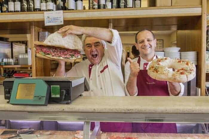 Two vendors at a pizza shop in Rome. 