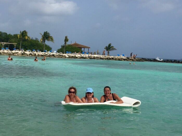 Three women on a floating lounger enjoying a Renaissance Aruba Day Pass