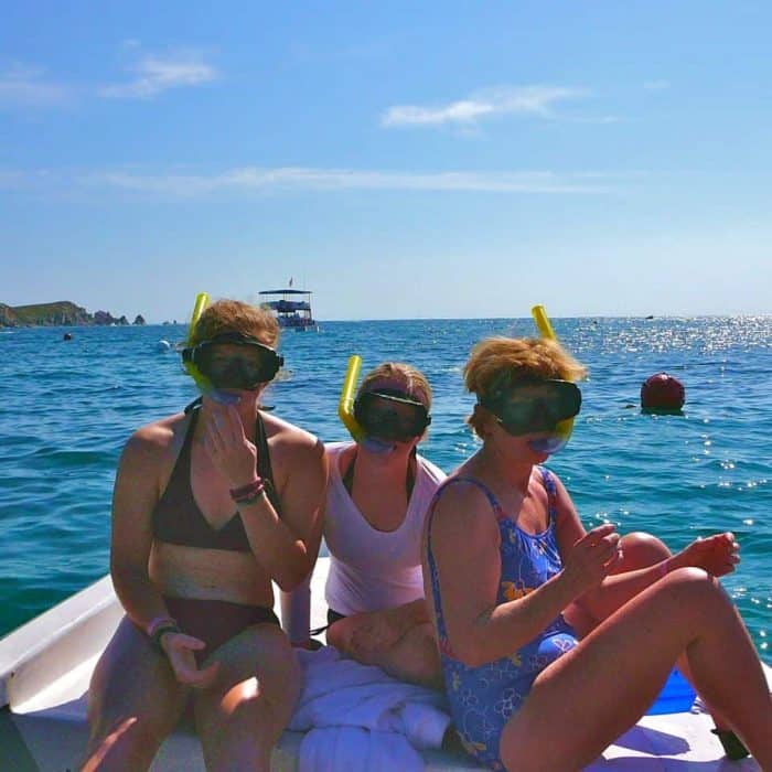 Three women with snorkeling masks ready to go snorkeling in Huatulco at San Agustin Bay.. 