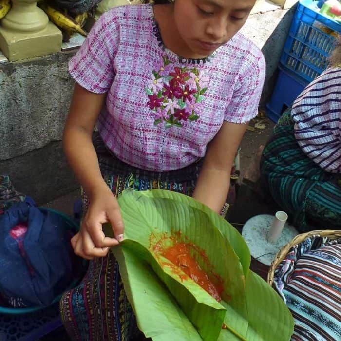 Vendor in the Santiago Atitlan market with patin wrapped in hoja de maxán