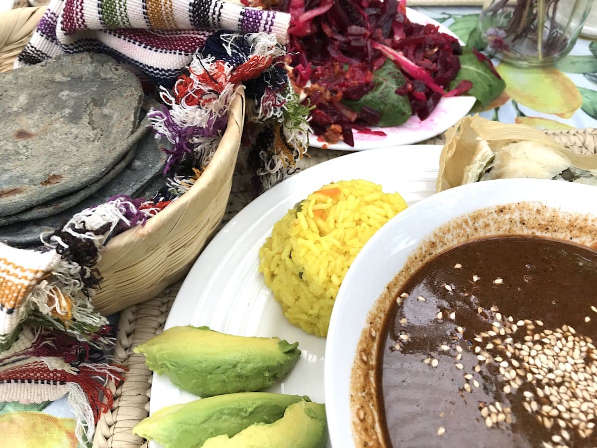 Pepian, blue corn tortillas, rice and avocado on a plate at Sabe Rico restaurant in Antigua Guatemala.