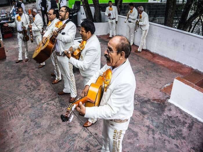 Mariachi musicians in white suites playing best Mariachi Songs to Request by Benjamin Patin on Unsplash