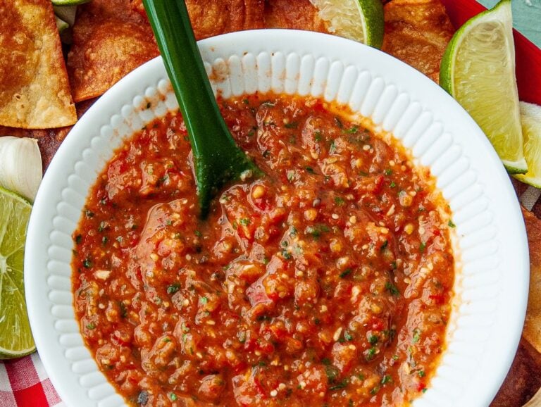 Homemade freezer salsa i a white bowl on a tablecloth.