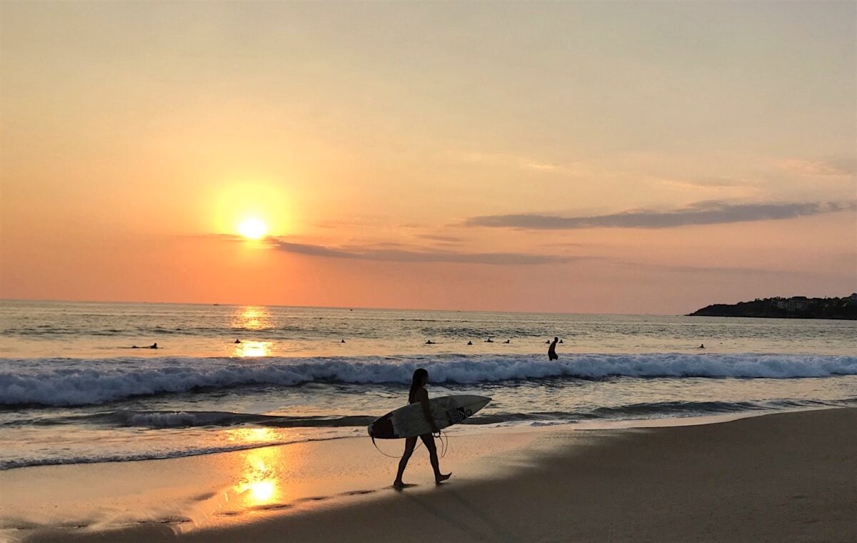 Surfer at sunset on the beach in Puerto Escondido Oaxaca.