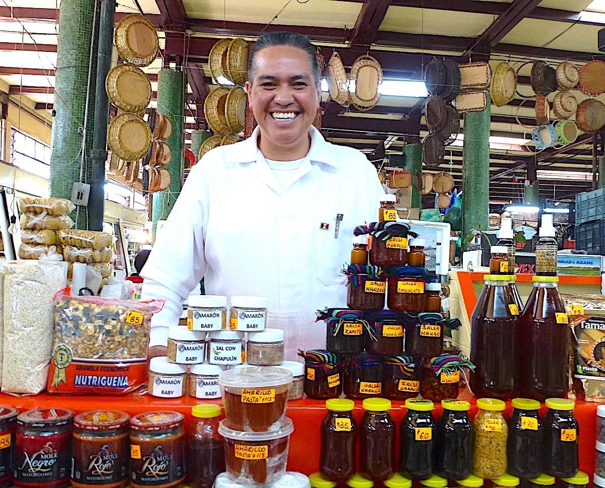 Smiling vendor at a stall at Mercado San Juan in Mexico City.