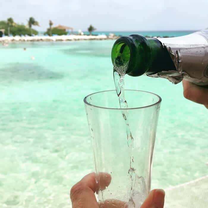 Champagne being poured into a glass during a luxury VIP experience at a private cabana at Renaissance Aruba Private Island.