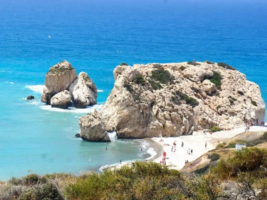 People swimming at Aphrodite's Rock in Cyprus.