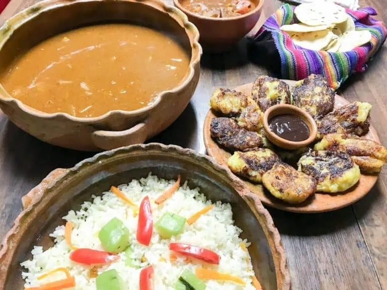 A selection of popular Guatemalan foods including rice, stuffed plantain and chicken pepian.