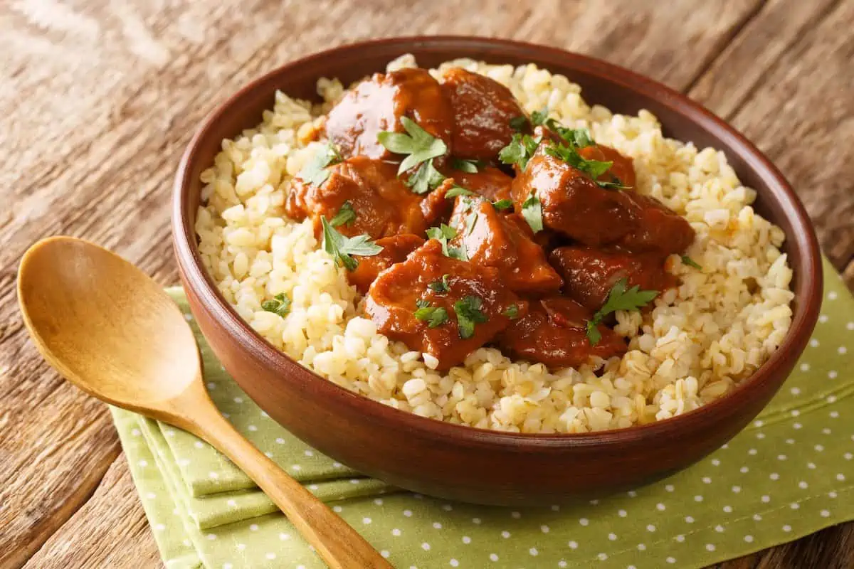 A brown bowl of afelia braised pork of Cyprus.