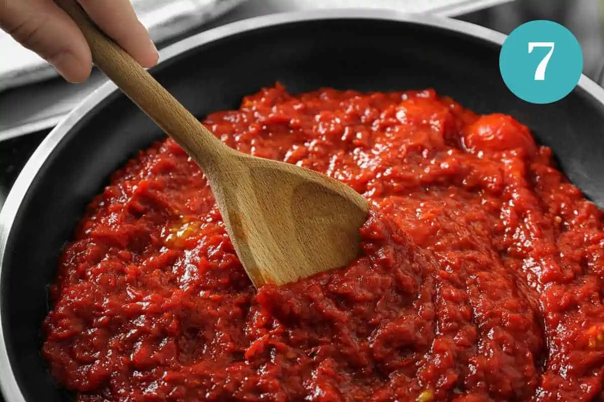 Cooking the tomatoes to make the sauce for bacalao.