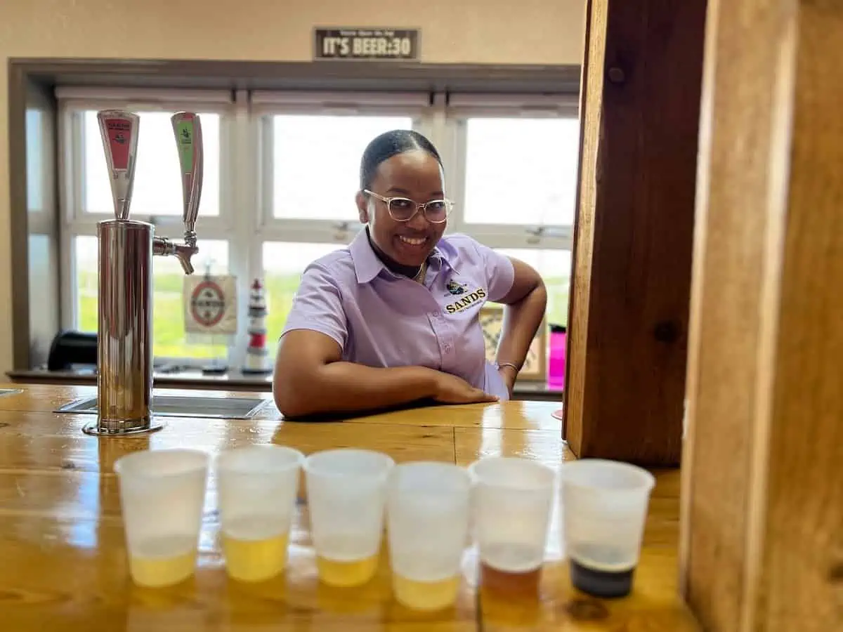 Bartender with samples of beer in cups. 