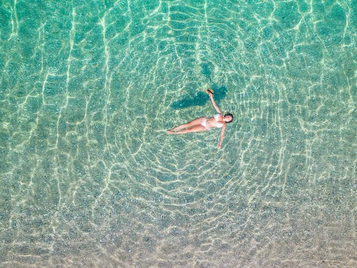 A woman floating in crystal-clear waters of the Mediterranean. 