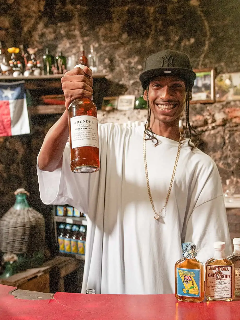 A young man serving rum at Callwood Rum Distillery.