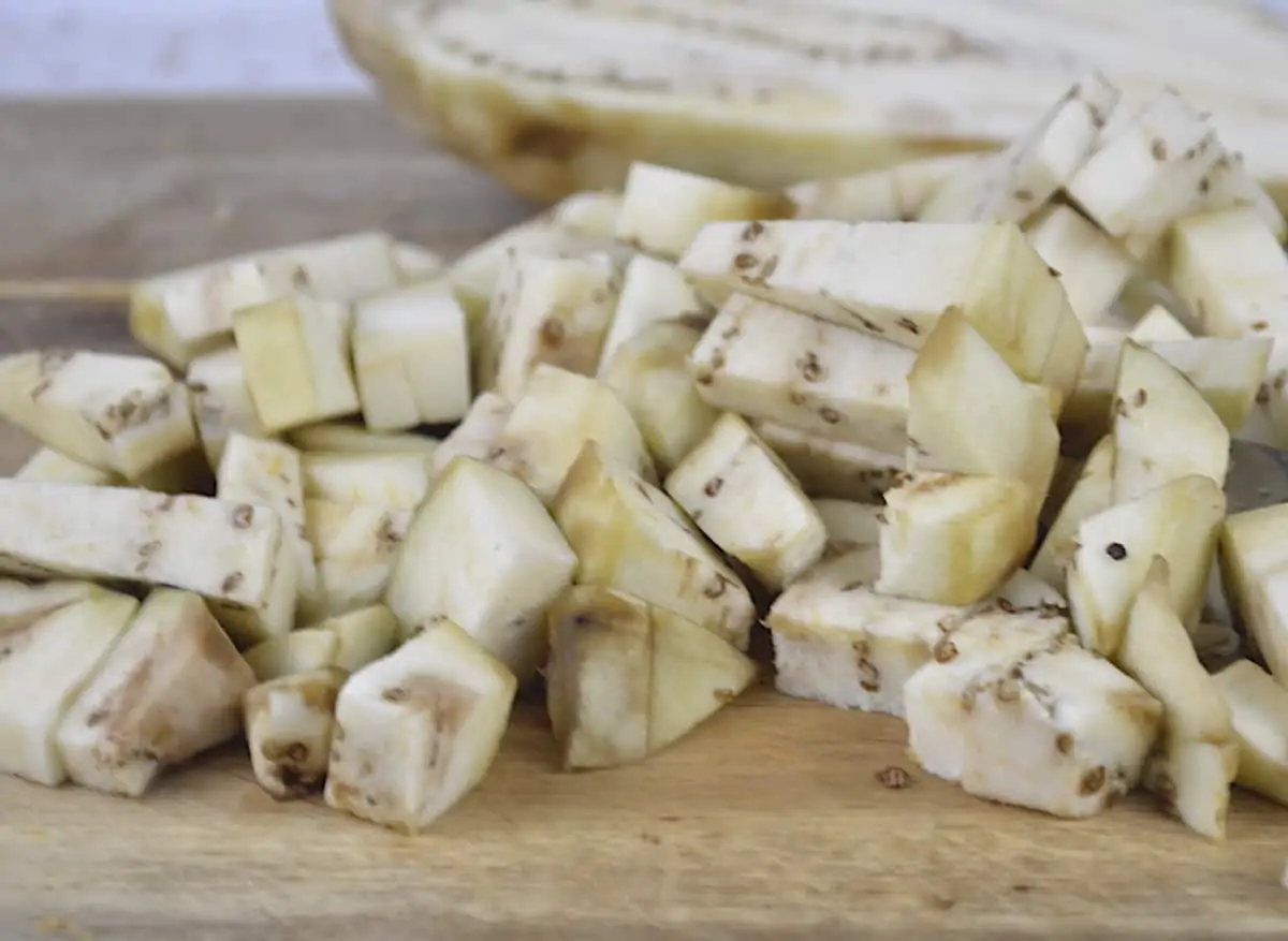 Chopped and diced eggplant on a wooden board.