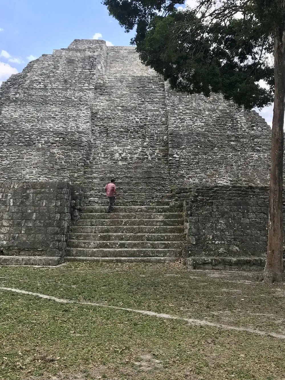 A man climbing a pyramid at Yaxha, Guatemala.