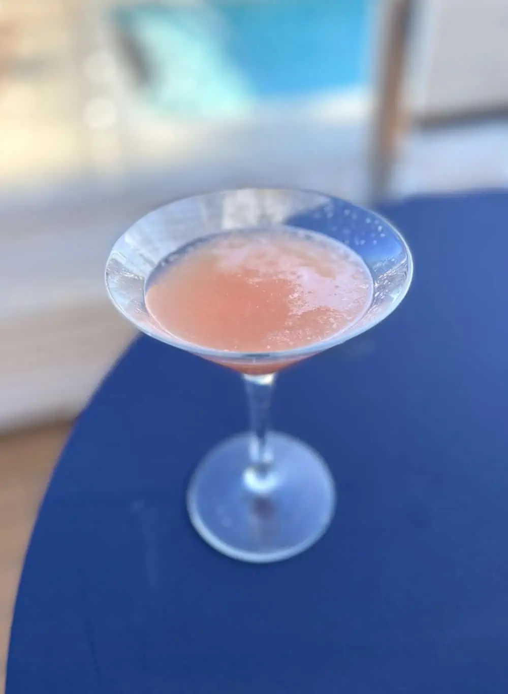 pale pink cocktail on a blue table. 