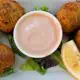 Conch Fritters on plate with sauce.