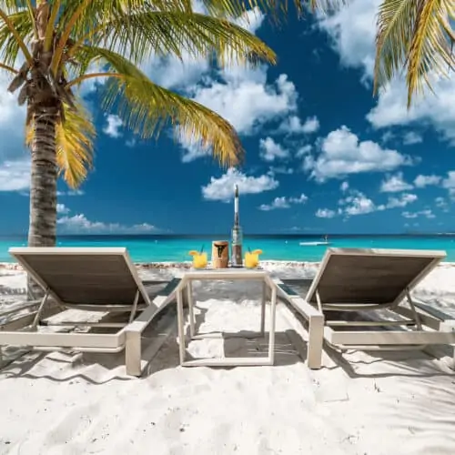 Two white loungers on a beach in Bonaire.