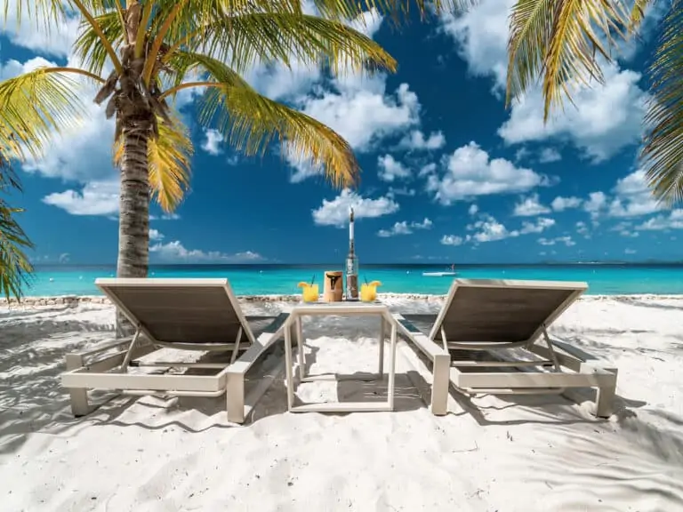 Two white loungers on a beach in Bonaire.