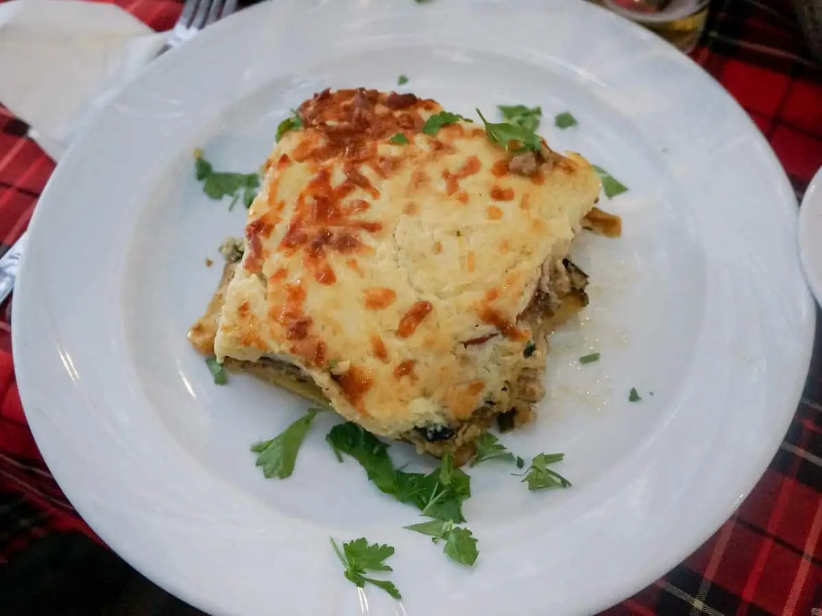 A slice of Cypriot moussaka on a white plate.