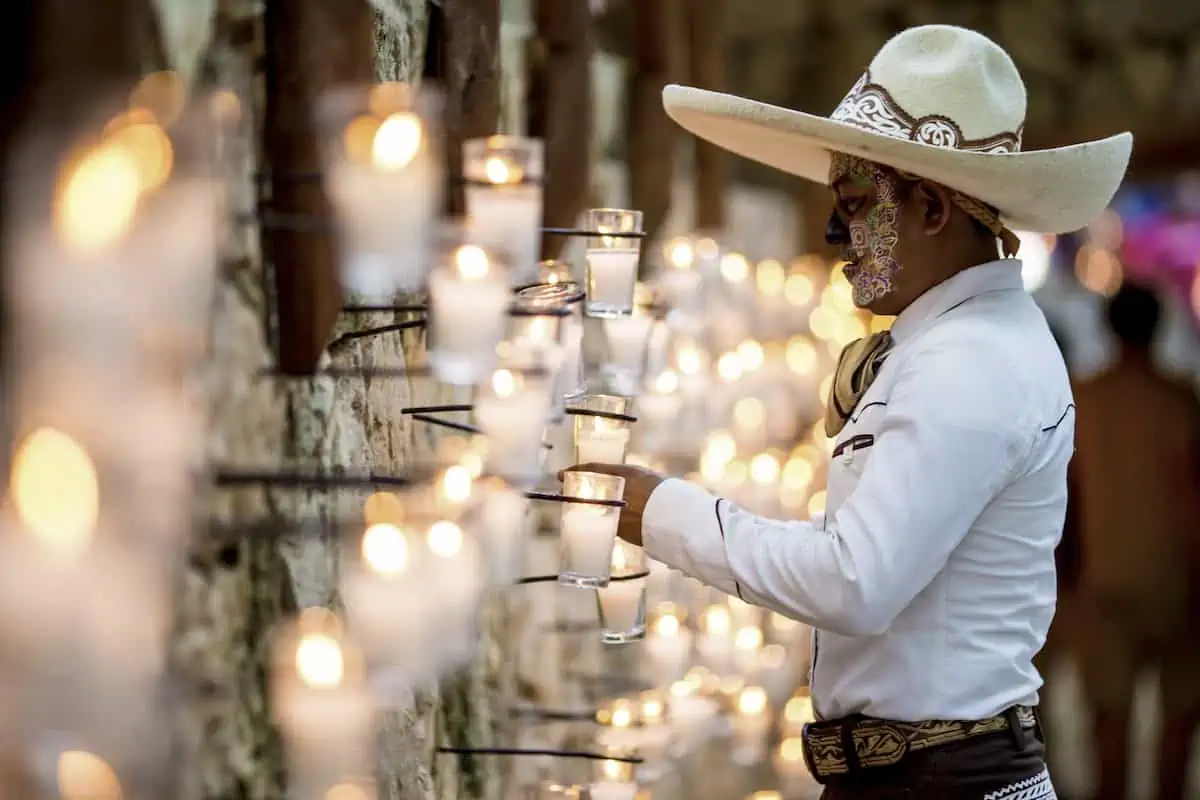 Young man in front of candles at festival of Life and Death Traditions in Mexico.