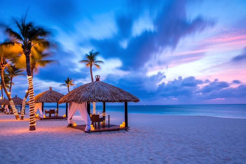 Row of Sunset Palapas on the beach at Bucuti & Tara resort in Aruba. 