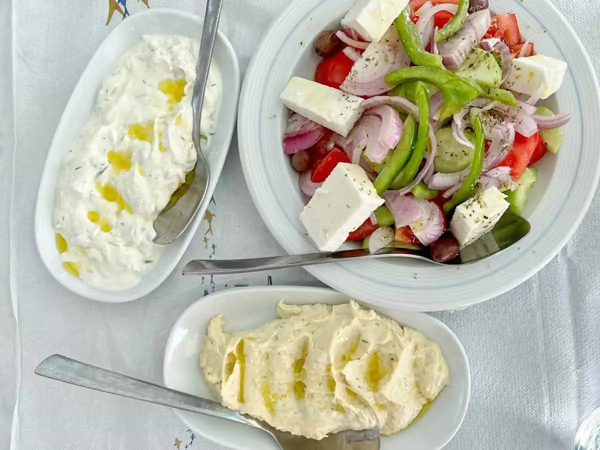 Regional food on white plates with spoons. 