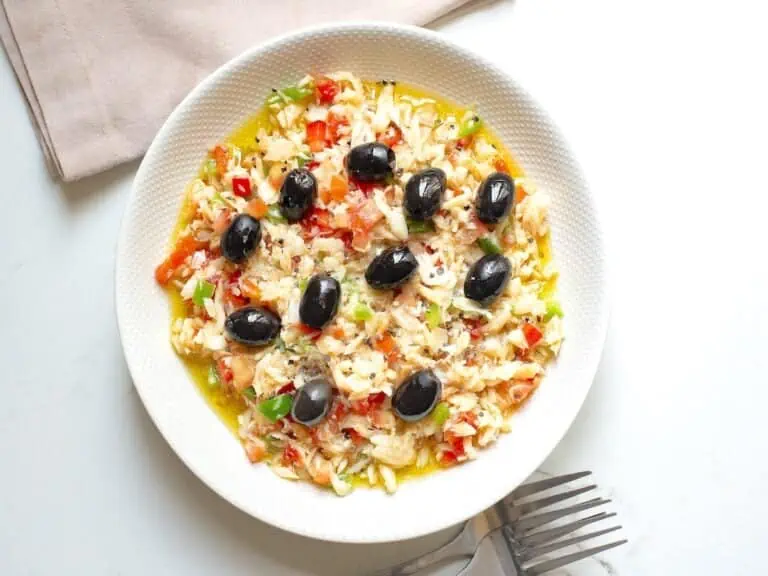 Esqueixada de bacalao catalana in a white plate with forks and a napkin.