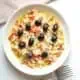 Esqueixada de bacalao catalana in a white plate with forks and a napkin.