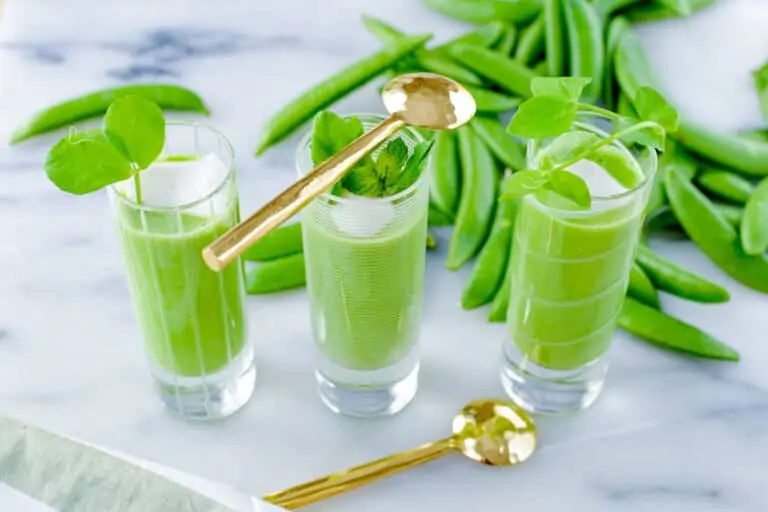 Chilled pea soup shooters with gold spoons.