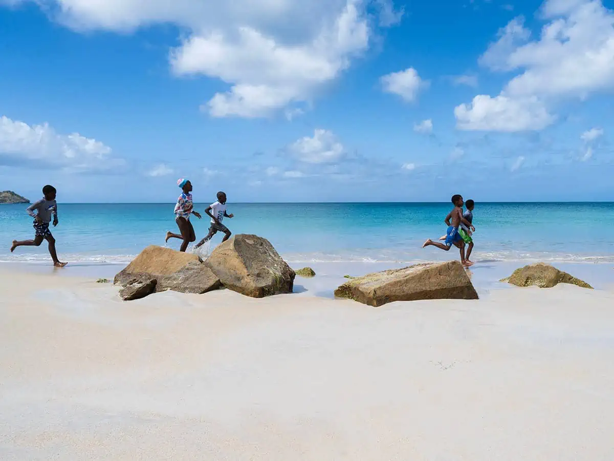 Five kids running along the sea shore.