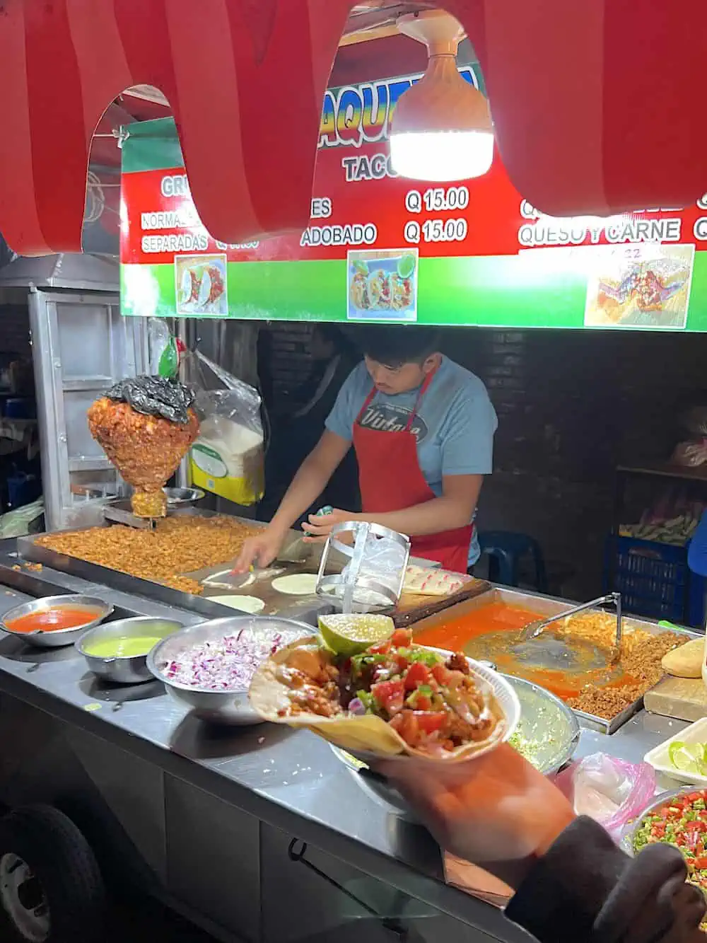 A street vendor skillfully grills the cheese so it melts for a gringa street food.