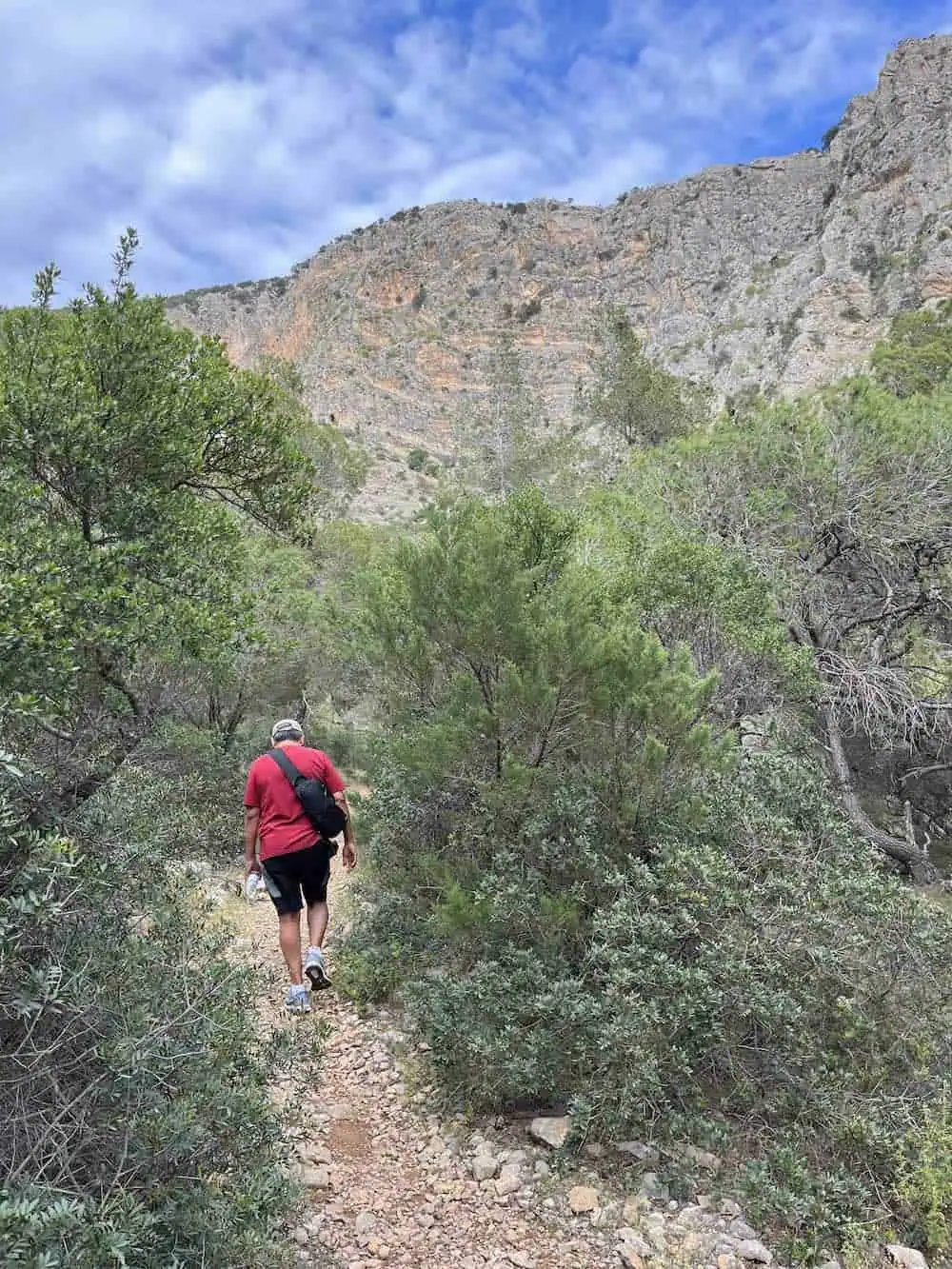 Man in a red shirt hiking a trail at Katafkyi Gorge.  