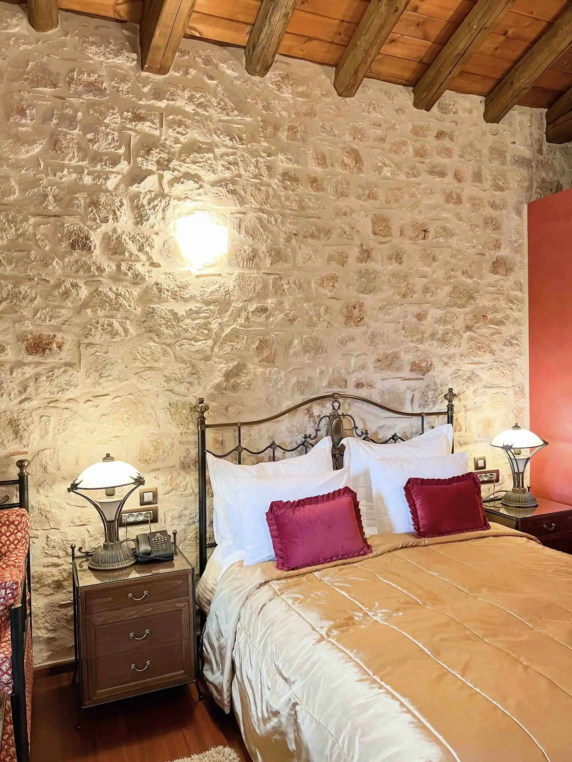 Interior of a villa at Mystras Grand Palace Hotel & Spa with bed and bedside table.