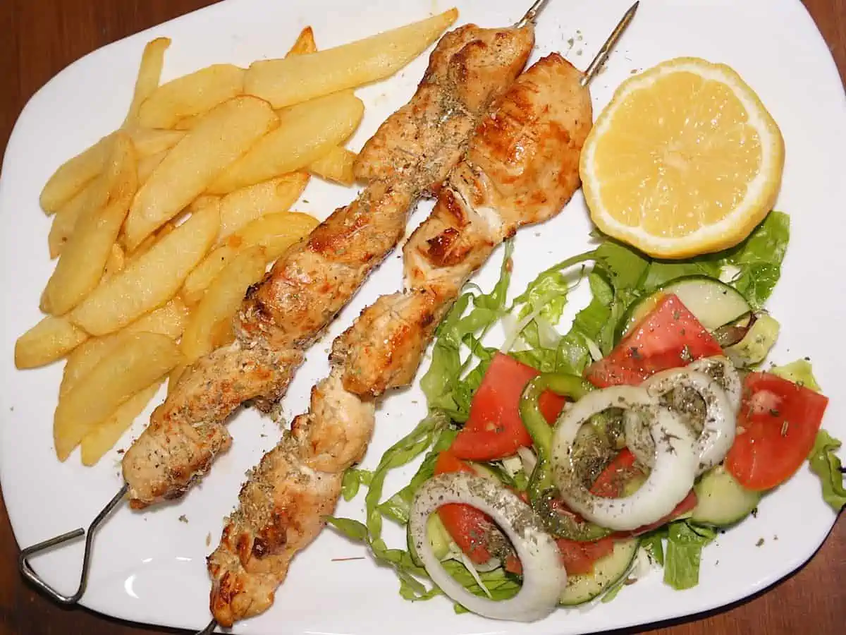 Cypriot Kebab on a white plate with salad.p