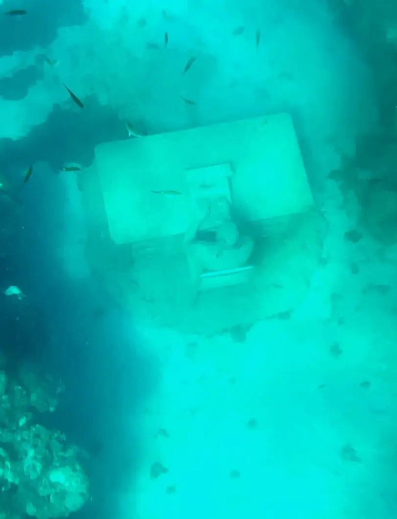 Sculpture of the Lost Correspondent underwater at the Molinere Underwater Sculpture Park. 