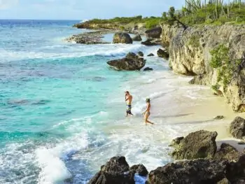 Couple entering water to go snorkeling in Bonaire.