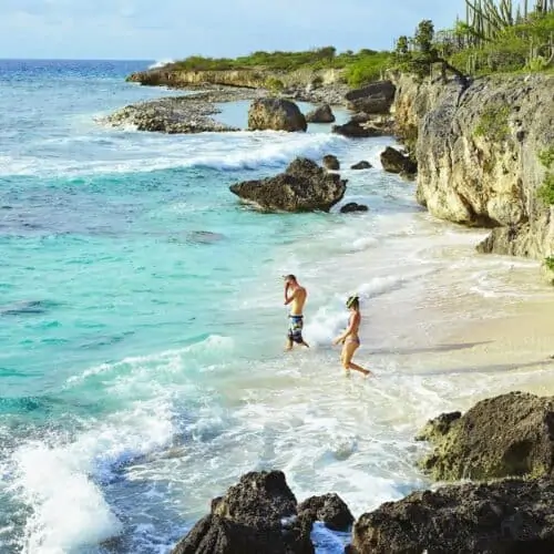 Couple entering water to go snorkeling in Bonaire.