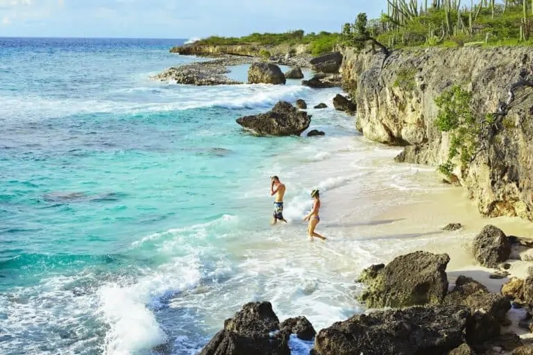 Couple entering water to go snorkeling in Bonaire.