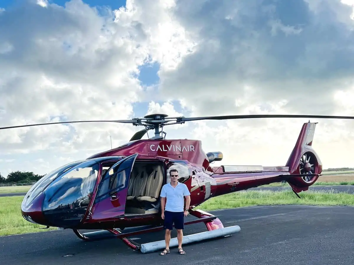 Mark Fleming Helicopter Pilot and CEO of Calvin Air in front of a helicopter.