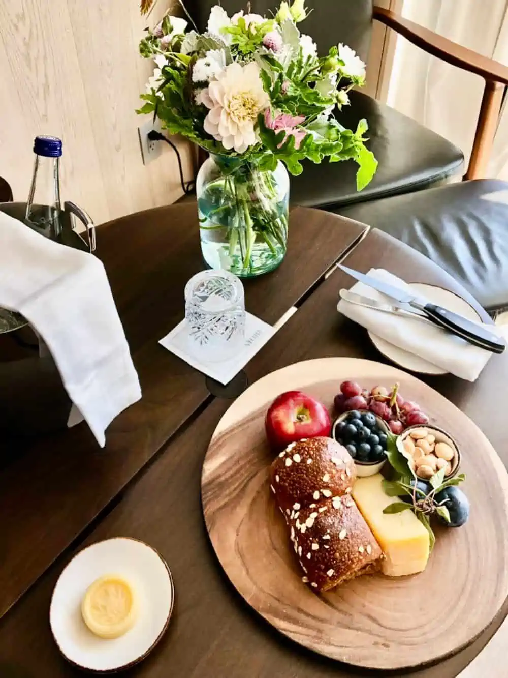 Brown Bread on plate on table with flowers and utensils.