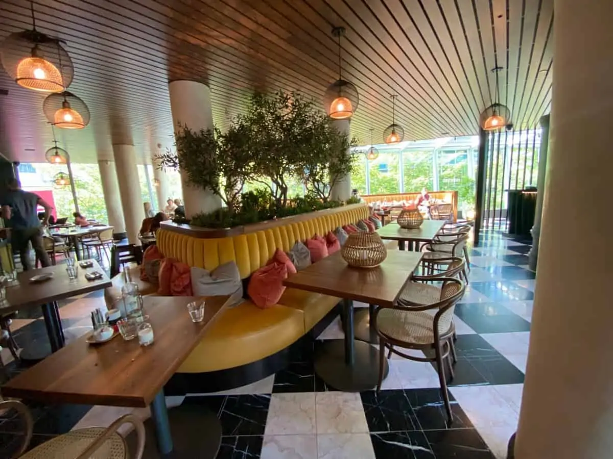 Tables with a long bench with white and black tiled floor in the Miantiao hotel.