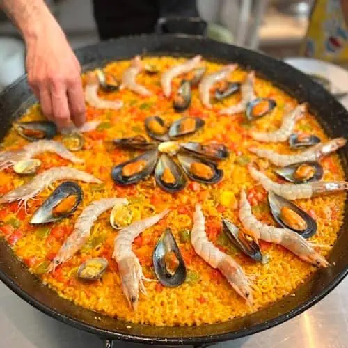 Chef making paella at a cooking class in Barcelona.