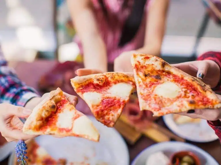 People on a food tour eating pizza.