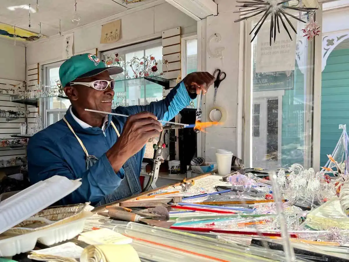 Man practicing glass blowing in shop. 